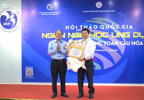 PGS-TS Chu Đình Lộc - Phó Hiệu trưởng Trường Đại học Khánh Hòa tặng hoa cho đại diện đơn vị đồng tổ chức hội thảo.